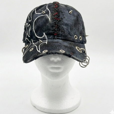 Tribal pattern cap with chain detail.
