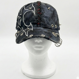 Tribal pattern cap with chain detail.